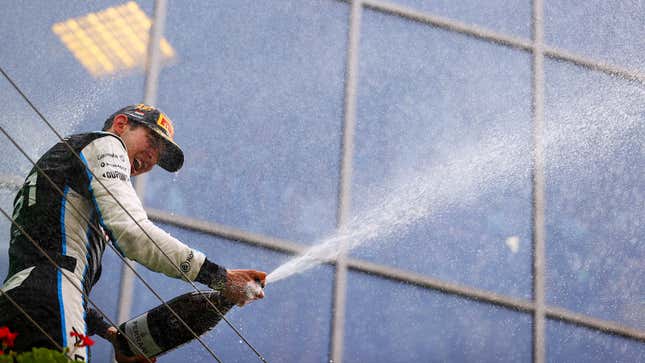 Foto Esteban Ocon menyemprotkan sampanye di podium tahun 2021. 